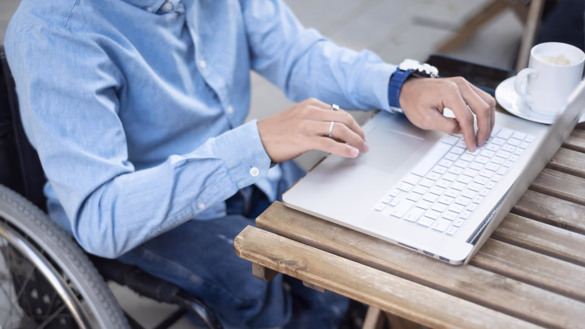 Man in wheelchair typing on laptop